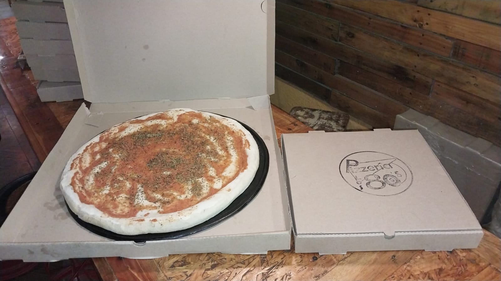 La pizza gigante de Los 80's al lado de una caja de pizza común